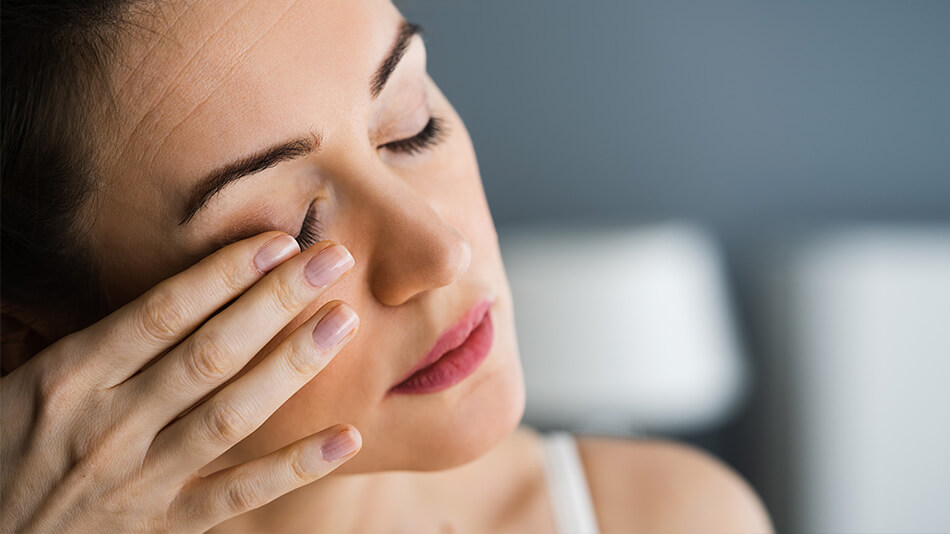 A beautiful woman touching her eyelid.